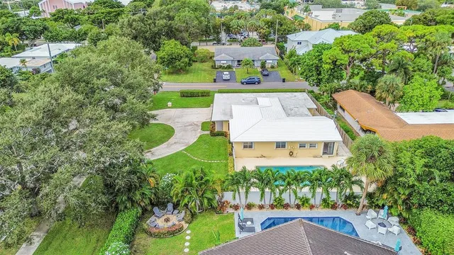 an aerial view of residential houses with outdoor space and trees