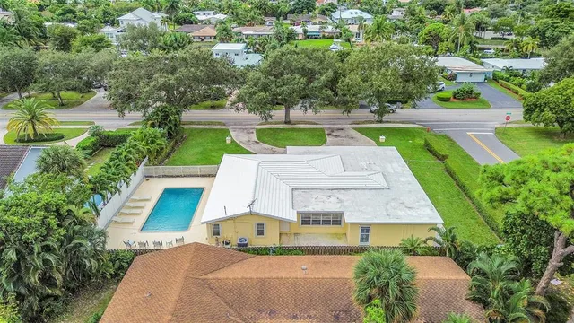an aerial view of residential houses with outdoor space and trees