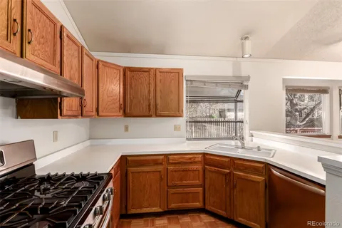 a kitchen with a sink stove top oven and cabinets
