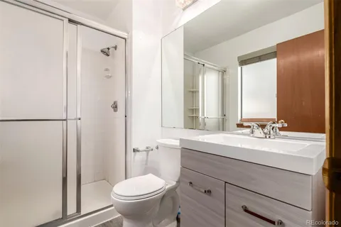 a bathroom with a sink toilet a mirror and shower