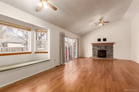 wooden floor fireplace and windows in an empty room