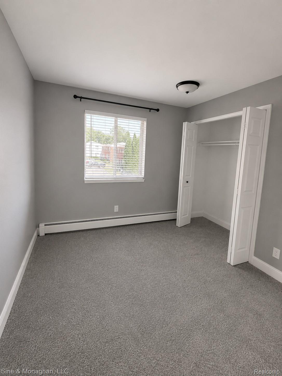433 Miller Avenue, Unit 203 Rochester, MI 48307 - Photo 7 of 12 Neutral grey walls with corresponding grey carpet