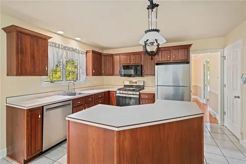 a kitchen with stainless steel appliances a refrigerator a stove top oven and a sink