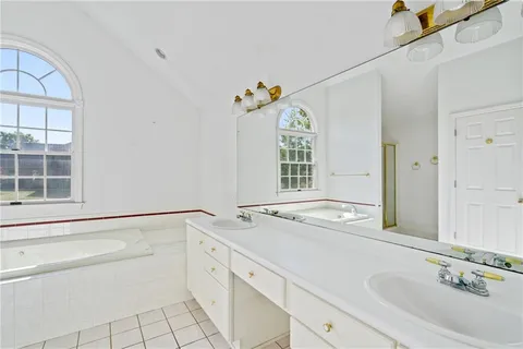a bathroom with a granite countertop sink a large mirror and a window