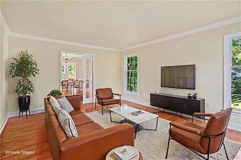 a living room with furniture a flat screen tv and a window