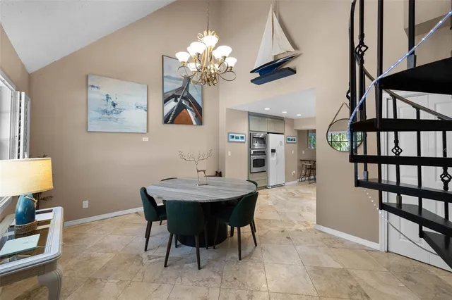 a dining room with furniture a chandelier and wooden floor