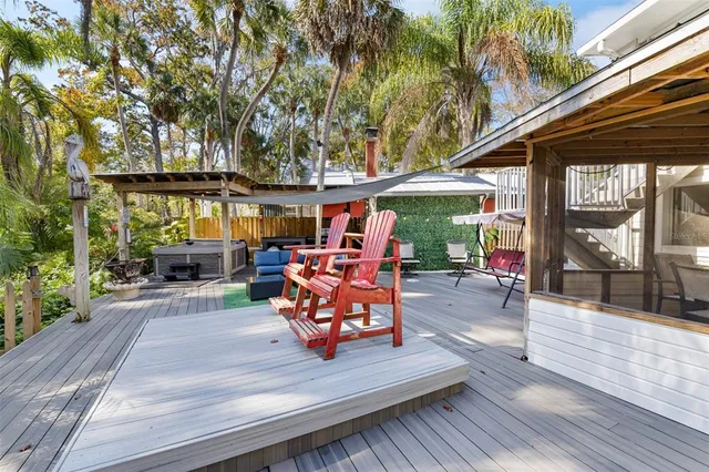 a backyard of a house with wooden floor and outdoor seating
