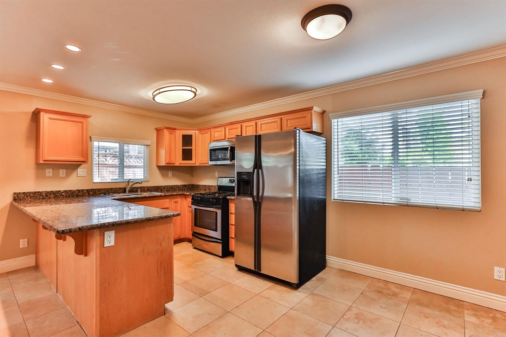 1133 Persimmon Avenue, Unit 7 El Cajon, CA 92021 - Photo 13 of 29 a kitchen with stainless steel appliances granite countertop a stove a sink and a refrigerator