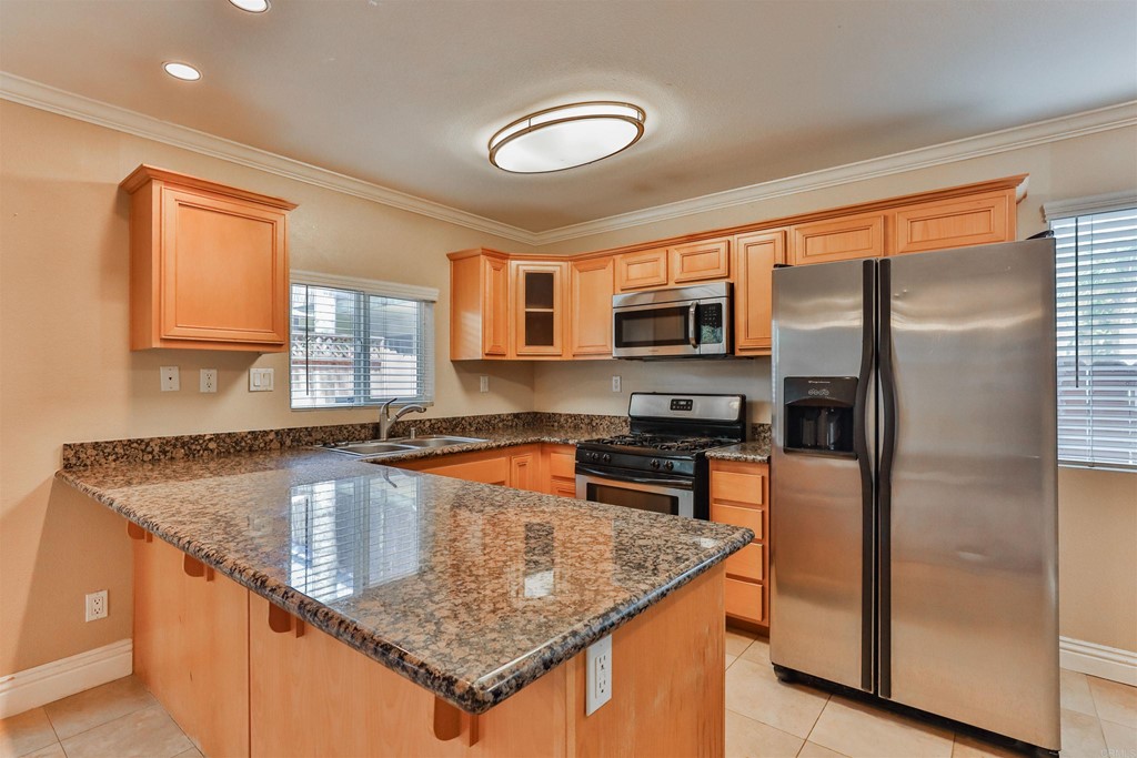 1133 Persimmon Avenue, Unit 7 El Cajon, CA 92021 - Photo 14 of 29 a kitchen with stainless steel appliances granite countertop a sink stove and refrigerator