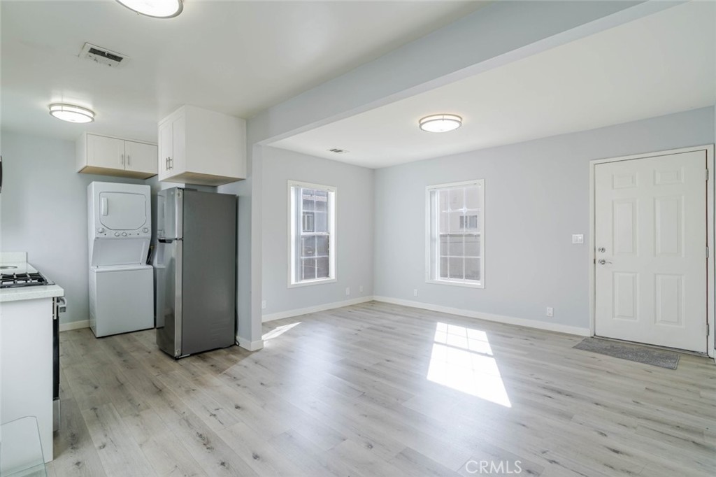 301 East Alameda Avenue, Unit A Burbank, CA 91502 - Photo 5 of 18 a view of a kitchen with a refrigerator wooden floor and a window
