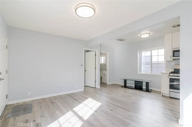 a view of empty room with wooden floor and window
