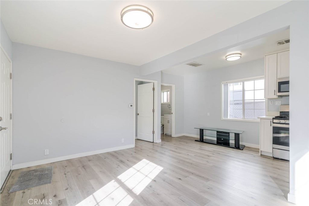 301 East Alameda Avenue, Unit A Burbank, CA 91502 - Photo 6 of 18 a view of empty room with wooden floor and window