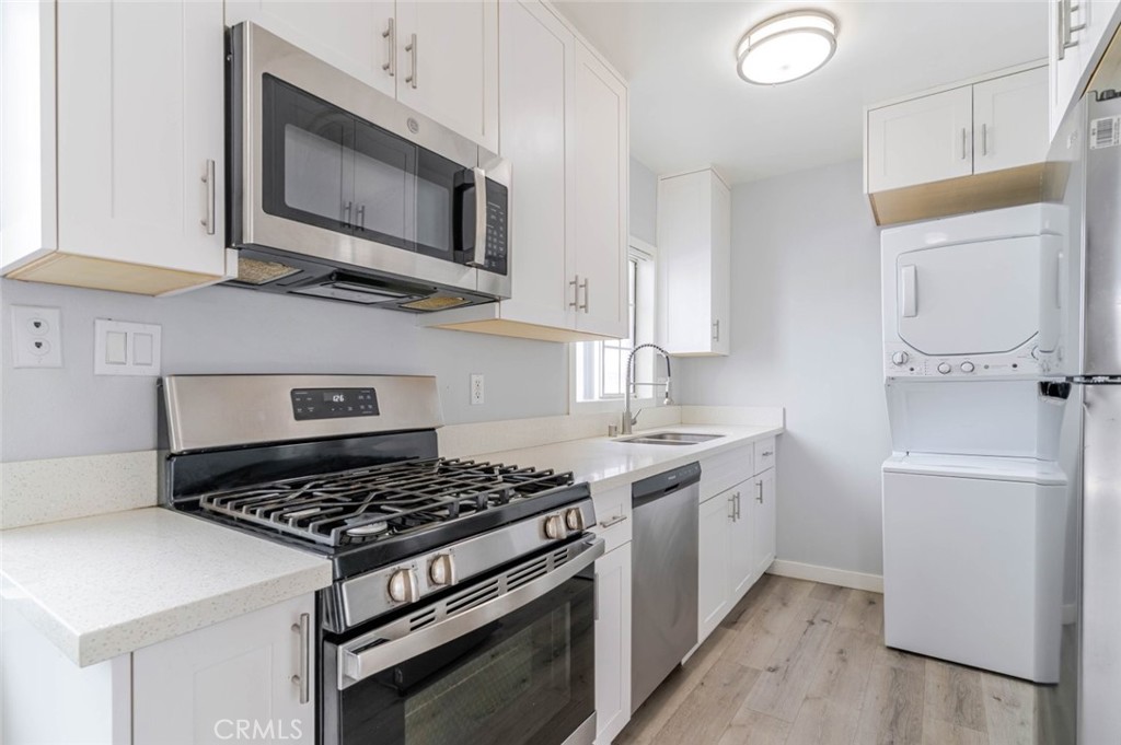 301 East Alameda Avenue, Unit A Burbank, CA 91502 - Photo 7 of 18 a kitchen with stainless steel appliances a stove a microwave and cabinets