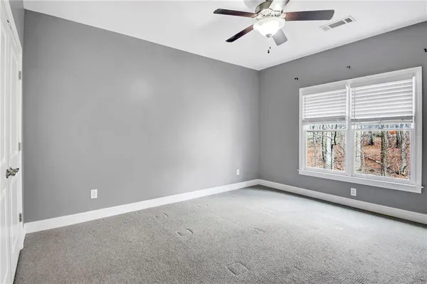 an empty room with a window and a ceiling fan
