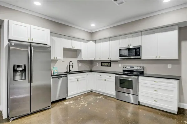 a kitchen with cabinets stainless steel appliances and a window