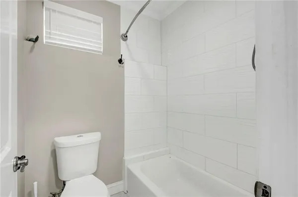 a white toilet sitting next to a bath tub