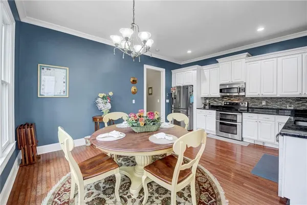 a view of a dining room with furniture a chandelier and wooden floor