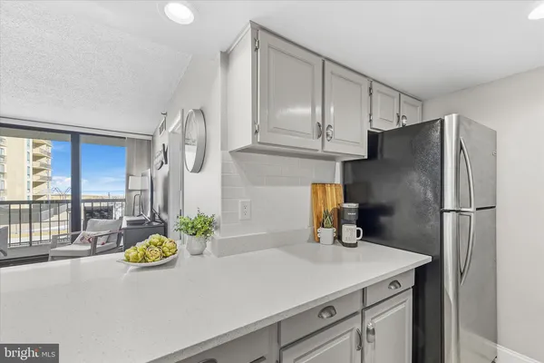 a kitchen with stainless steel appliances a sink a refrigerator cabinets and a window