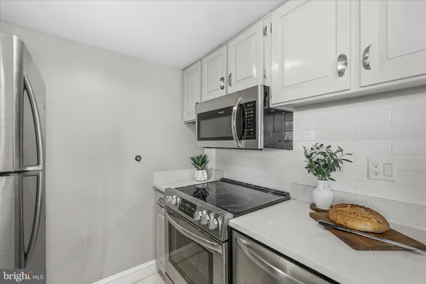 a kitchen with stainless steel appliances granite countertop a sink a stove a microwave and refrigerator