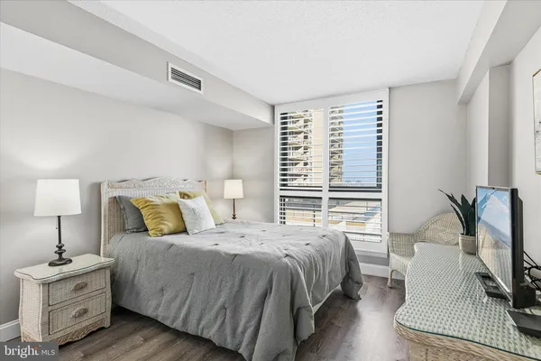 a spacious bedroom with a bed and a lamp