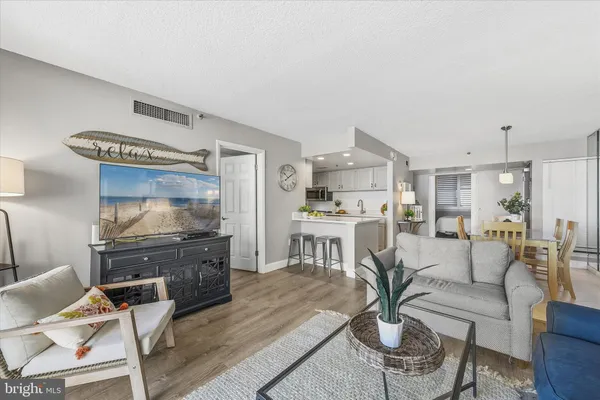 a living room with furniture a dining table and kitchen view