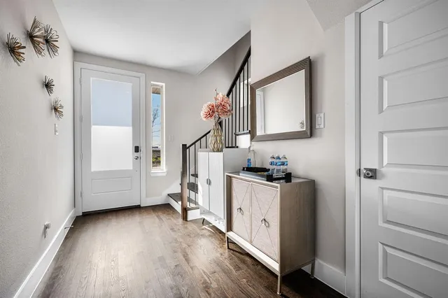 a view of a hallway with wooden floor and staircase