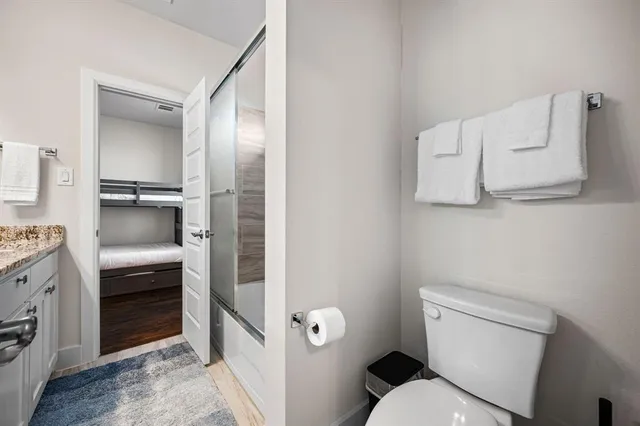 a bathroom with a granite countertop double vanity sink and a mirror