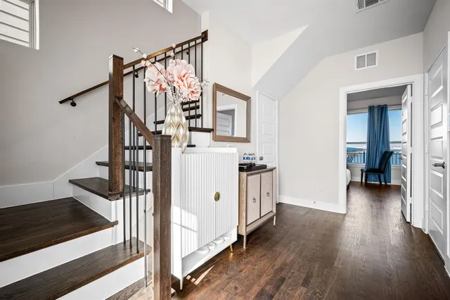 a view of a hallway with wooden floor and staircase