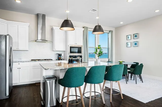 a kitchen with granite countertop white cabinets and stainless steel appliances