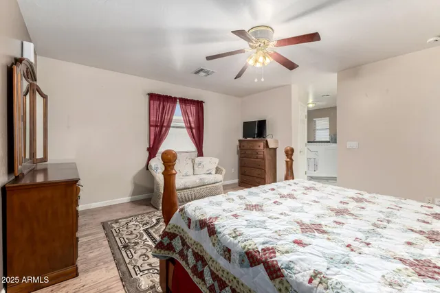 a bedroom with a bed and dresser with mirror