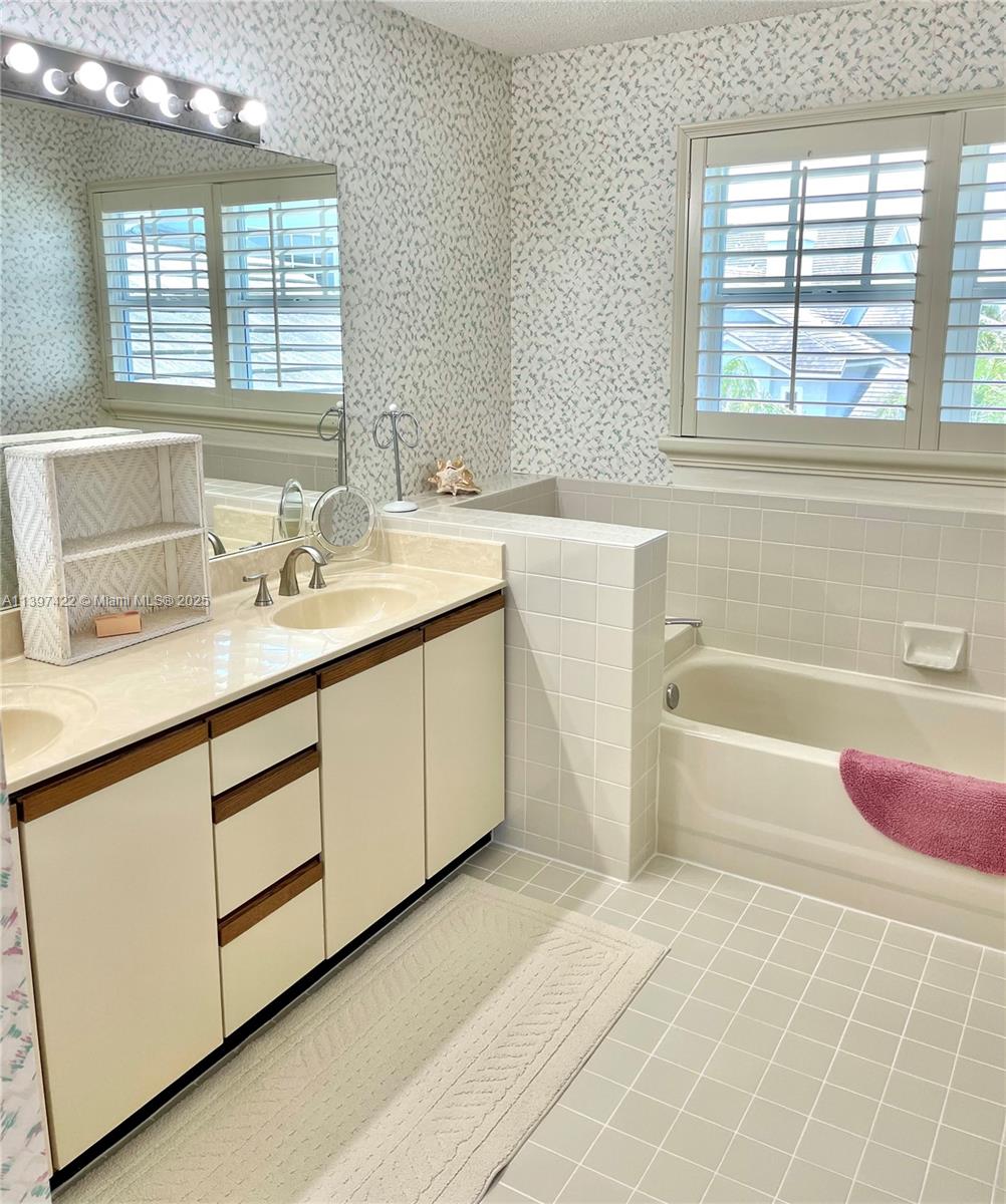 905 Mainsail Circle, Unit 905 Jupiter, FL 33477 - Photo 18 of 27 a bathroom with a tub sink and a mirror