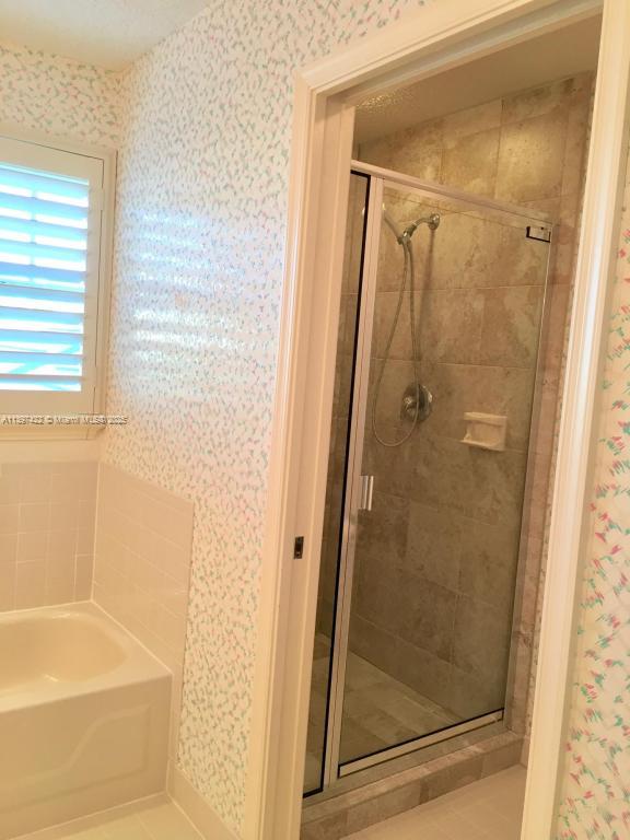 905 Mainsail Circle, Unit 905 Jupiter, FL 33477 - Photo 19 of 27 a bathroom with a glass shower door