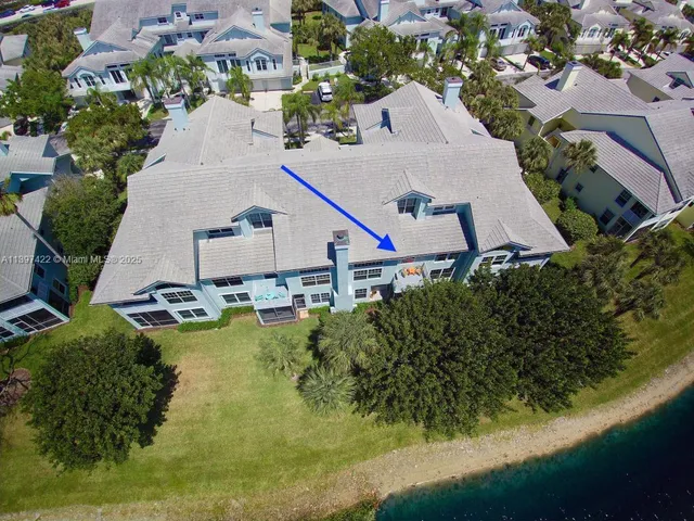 an aerial view of a house with swimming pool and lake view