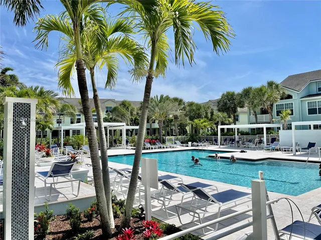 a view of a swimming pool with a garden and patio