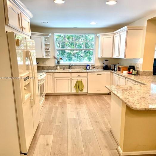 905 Mainsail Circle, Unit 905 Jupiter, FL 33477 - Photo 5 of 27 a large white kitchen with a stove a sink and dishwasher a refrigerator with wooden floor