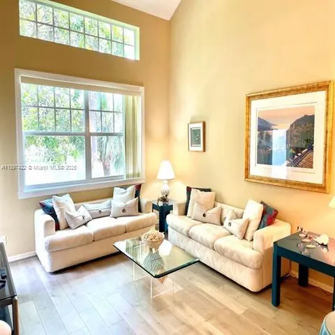 a living room with furniture and a window with wooden floor