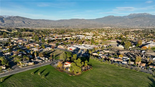 an aerial view of residential houses with outdoor space and trees