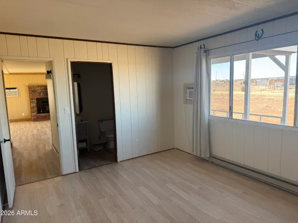 a view of hallway with a large window and wooden floor