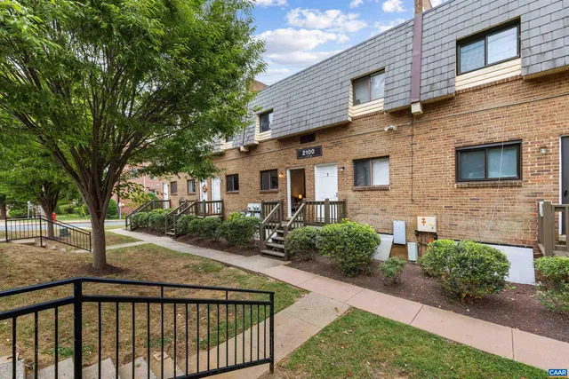 a view of a brick house next to a yard