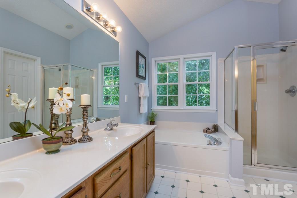 12304 Hartwick Court Raleigh, NC 27613 - Photo 9 of 14 a bathroom with a tub sink and mirror