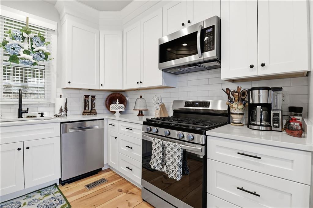 59 Falcon Heights Jasper, GA 30143 - Photo 20 of 47 a kitchen with stainless steel appliances granite countertop white cabinets a stove a sink and a microwave