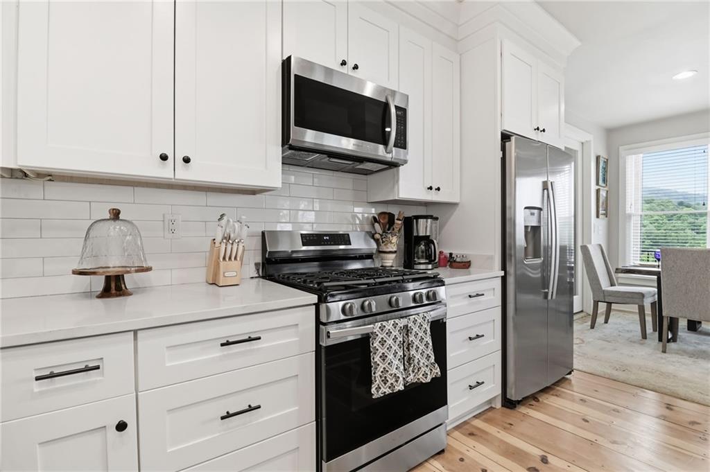 59 Falcon Heights Jasper, GA 30143 - Photo 22 of 47 a kitchen with stainless steel appliances white cabinets and a stove a oven with wooden floor