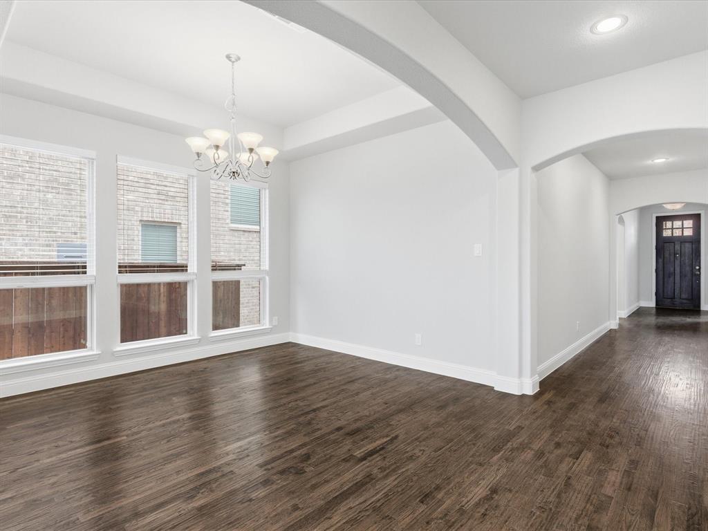2217 Commons Way Prosper, TX 75078 - Photo 12 of 37 Unfurnished dining area with arched walkways, dark wood finished floors, a chandelier, a tray ceiling, and recessed lighting