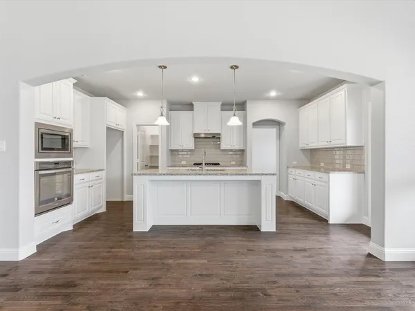 a large kitchen with kitchen island a sink stainless steel appliances and cabinets