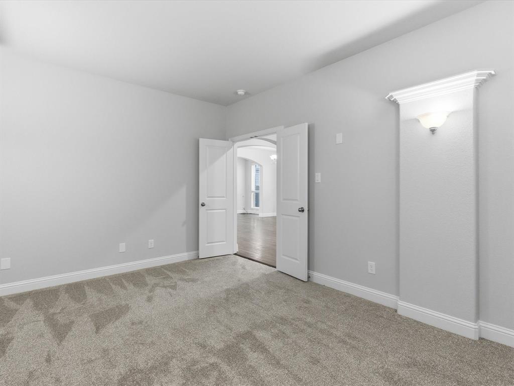 2217 Commons Way Prosper, TX 75078 - Photo 20 of 37 Unfurnished bedroom featuring arched walkways and light colored carpet
