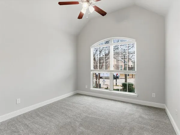 an empty room with windows and ceiling fan