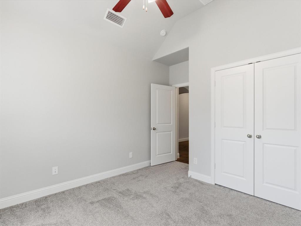 2217 Commons Way Prosper, TX 75078 - Photo 22 of 37 Unfurnished bedroom featuring light colored carpet, lofted ceiling, a ceiling fan, and a closet