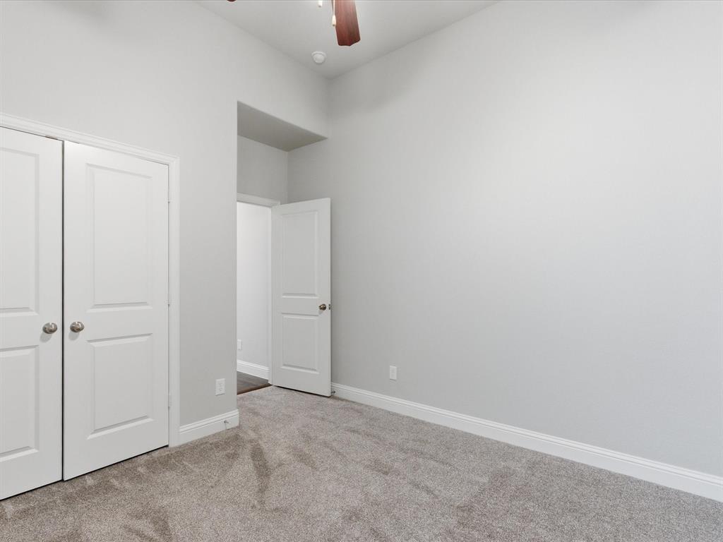 2217 Commons Way Prosper, TX 75078 - Photo 24 of 37 Unfurnished bedroom with light colored carpet, a closet, and a ceiling fan