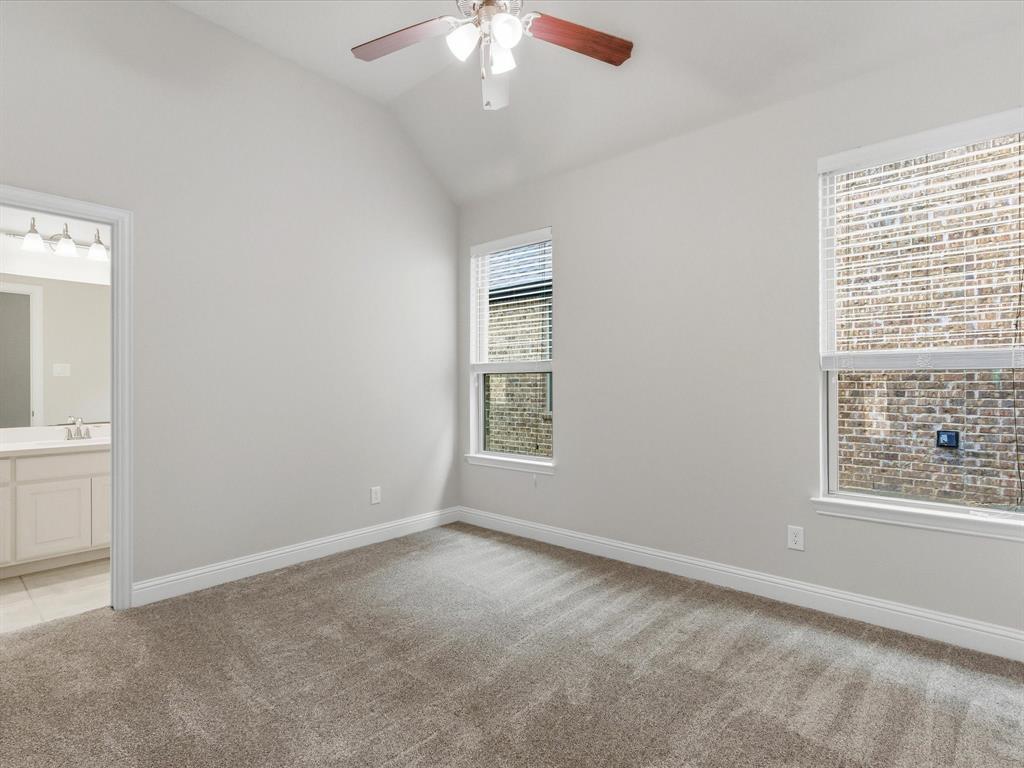 2217 Commons Way Prosper, TX 75078 - Photo 27 of 37 Unfurnished bedroom with vaulted ceiling, light carpet, ensuite bathroom, and ceiling fan