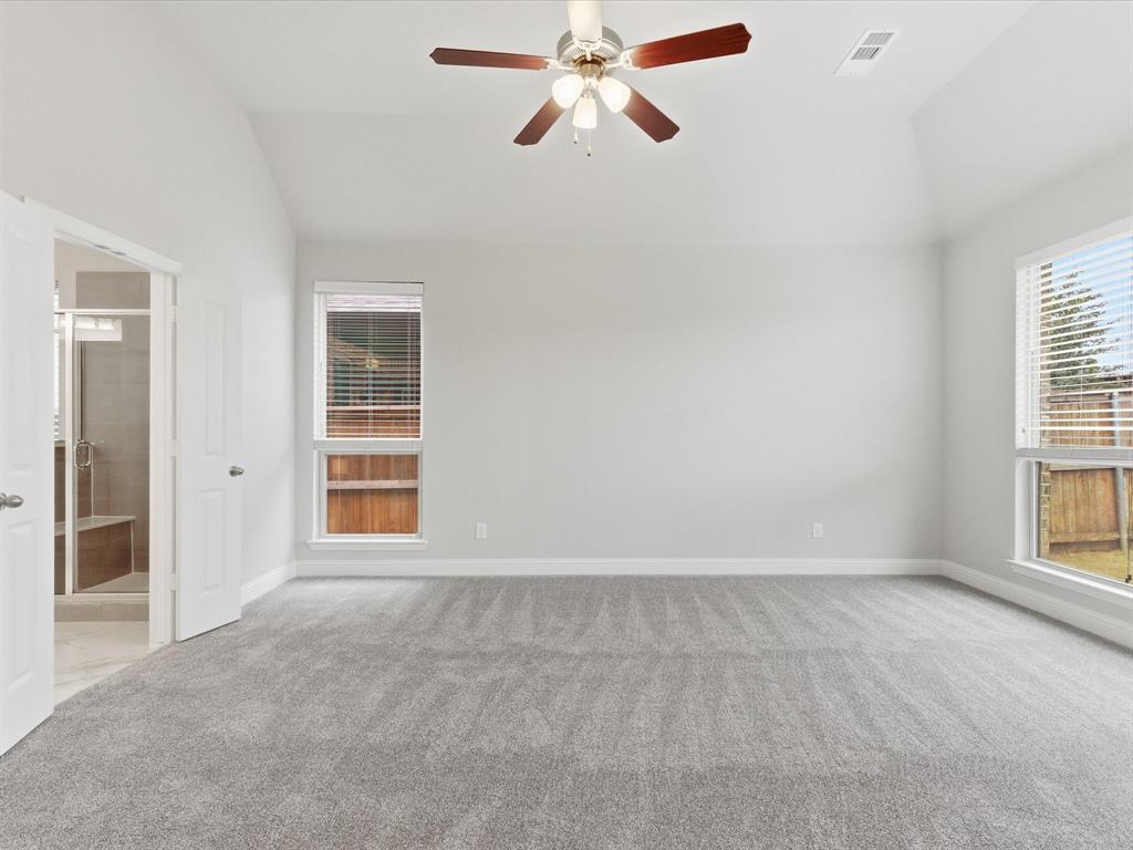 2217 Commons Way Prosper, TX 75078 - Photo 28 of 37 Empty room with vaulted ceiling, light colored carpet, and a ceiling fan